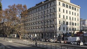 Un edificio de varios pisos con estilo arquitectónico clásico, que presenta una fachada simétrica con ventanas regularmente distribuidas y una entrada central.