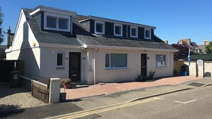 A two-story building with a flat roof, a front door, and a small porch area. - Silverstrands Guest House (Inverness)
