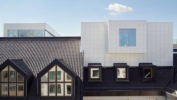 A modern building with a sloped roof, multiple windows, and a flat facade.
