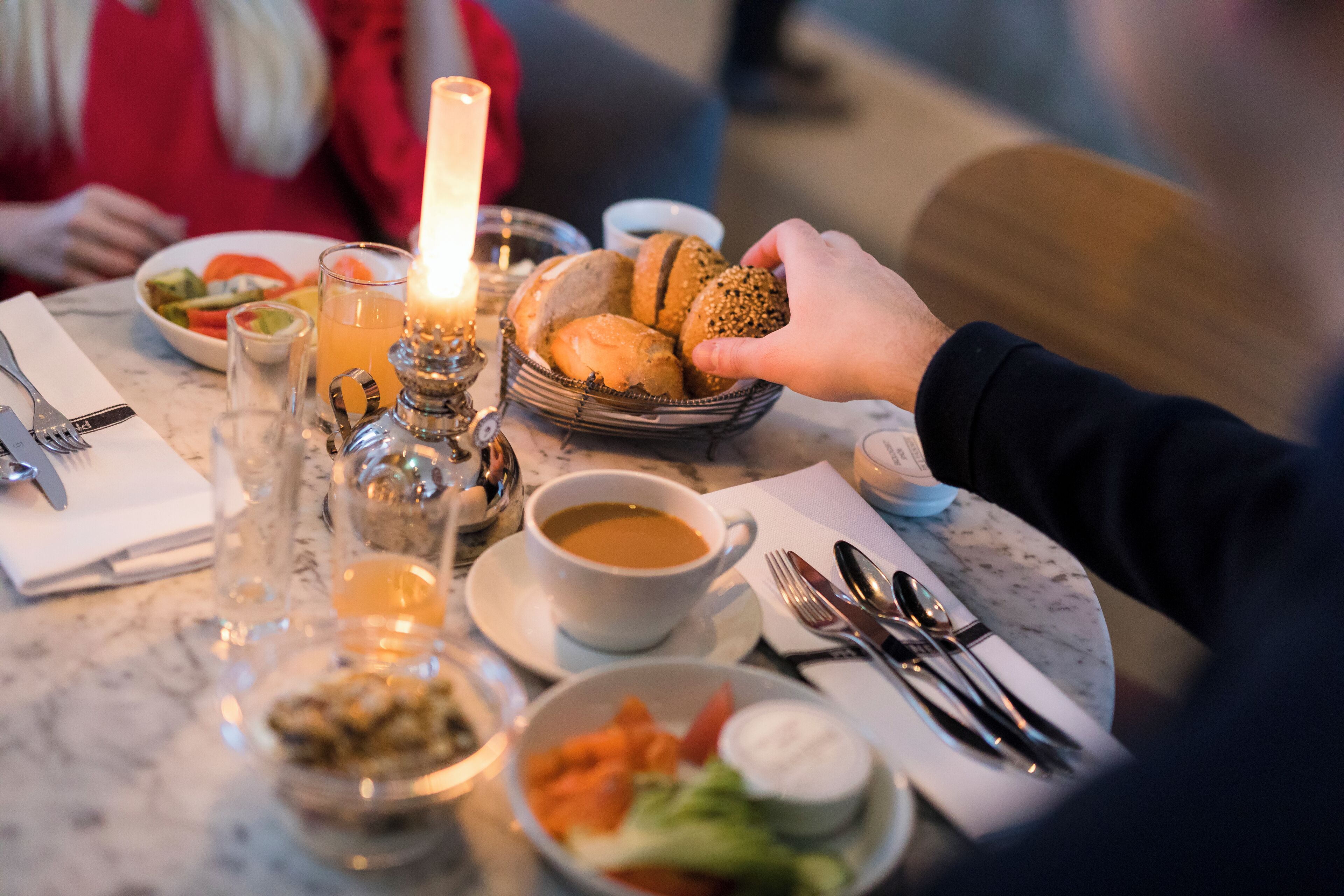 A dining table with various dishes, including bread, salad, and a cup of coffee.