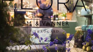 A view of a restaurant with a window display featuring purple flowers and glasses of water.