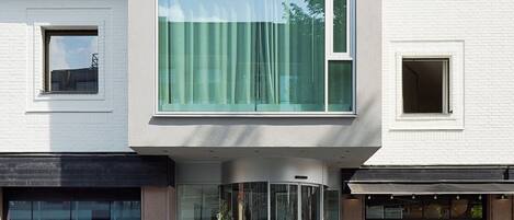 Un edificio moderno de dos pisos con amplias ventanas y entrada de vidrio.