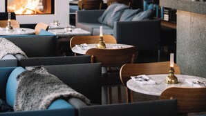 A modern interior with a fireplace, seating area, and a bookshelf. - PM & Vänner Hotel (Växjö)