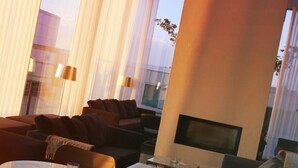 A modern living room with a sofa, armchairs, a coffee table, and a flat-screen TV. - PM & Vänner Hotel (Växjö)