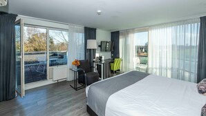 A hotel room with a large bed, a desk, a chair, and a TV. - Grand Hotel Amstelveen (Amstelveen)