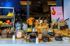 A breakfast buffet with various food items and condiments. - Grand Hotel Amstelveen (Amstelveen)