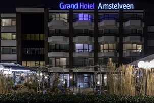A hotel with a modern design, featuring multiple balconies and a well-lit entrance.