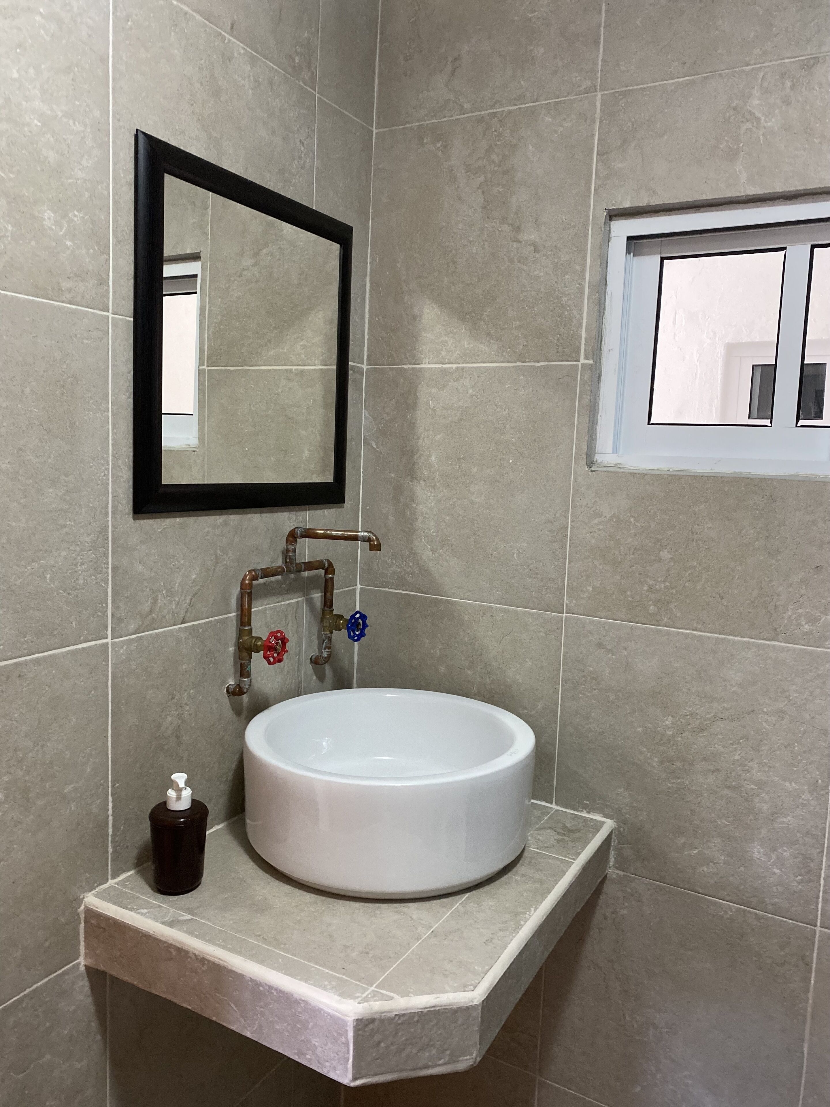 Ein Badezimmer mit Waschbecken, Spiegel und Fenster.