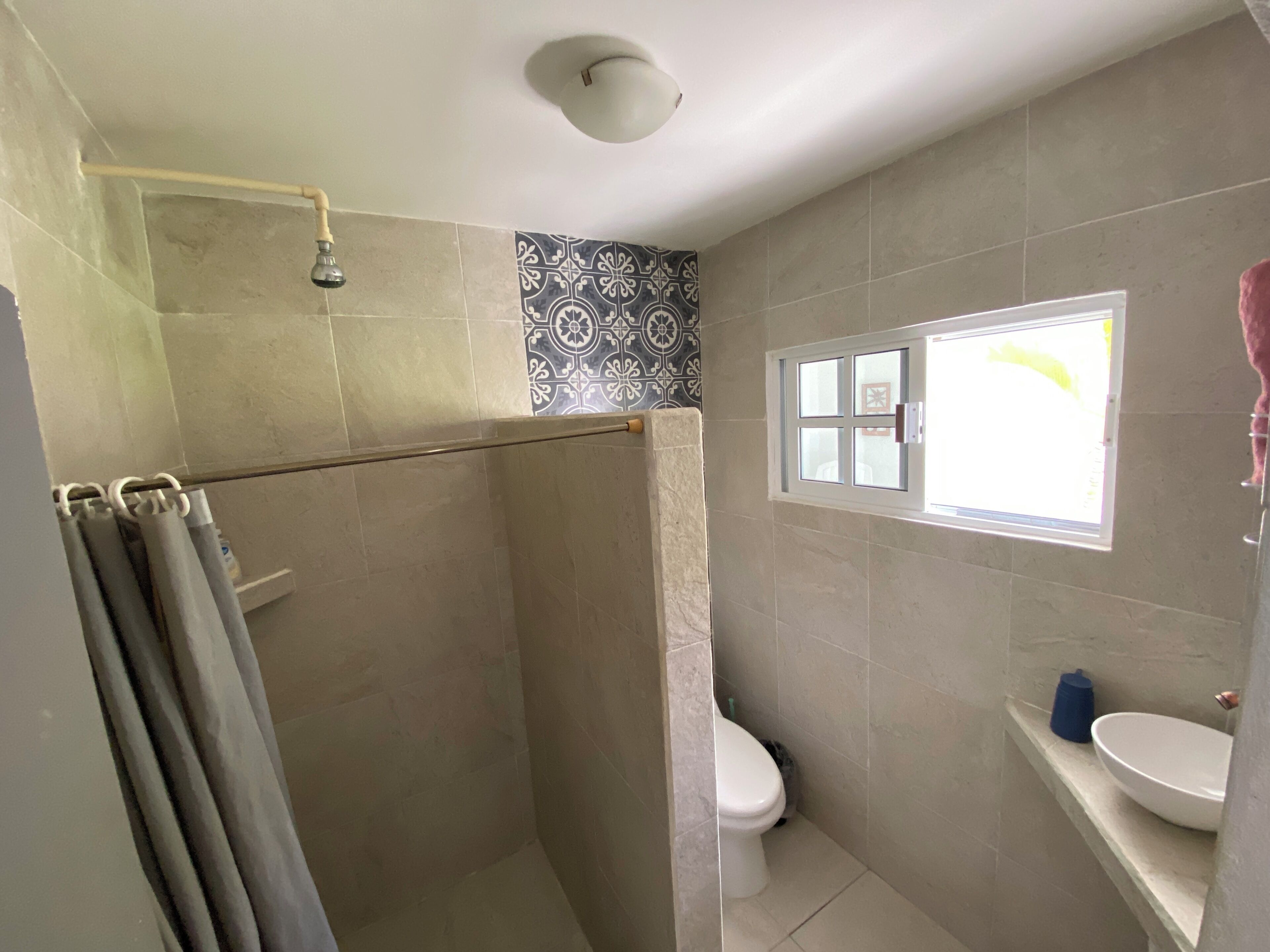 A bathroom with a shower, toilet, and sink.