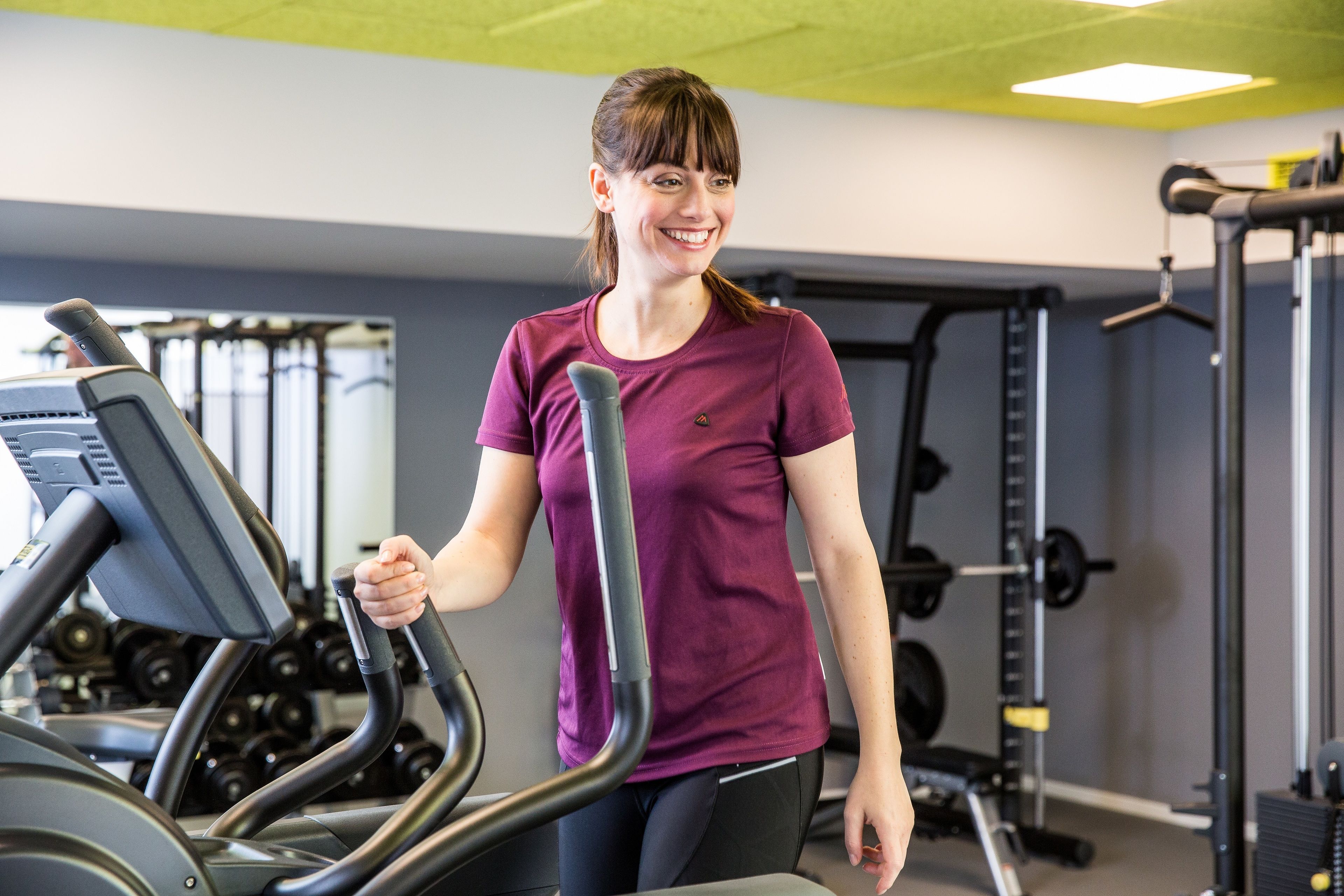 A gym with treadmills, weight machines, and dumbbells.