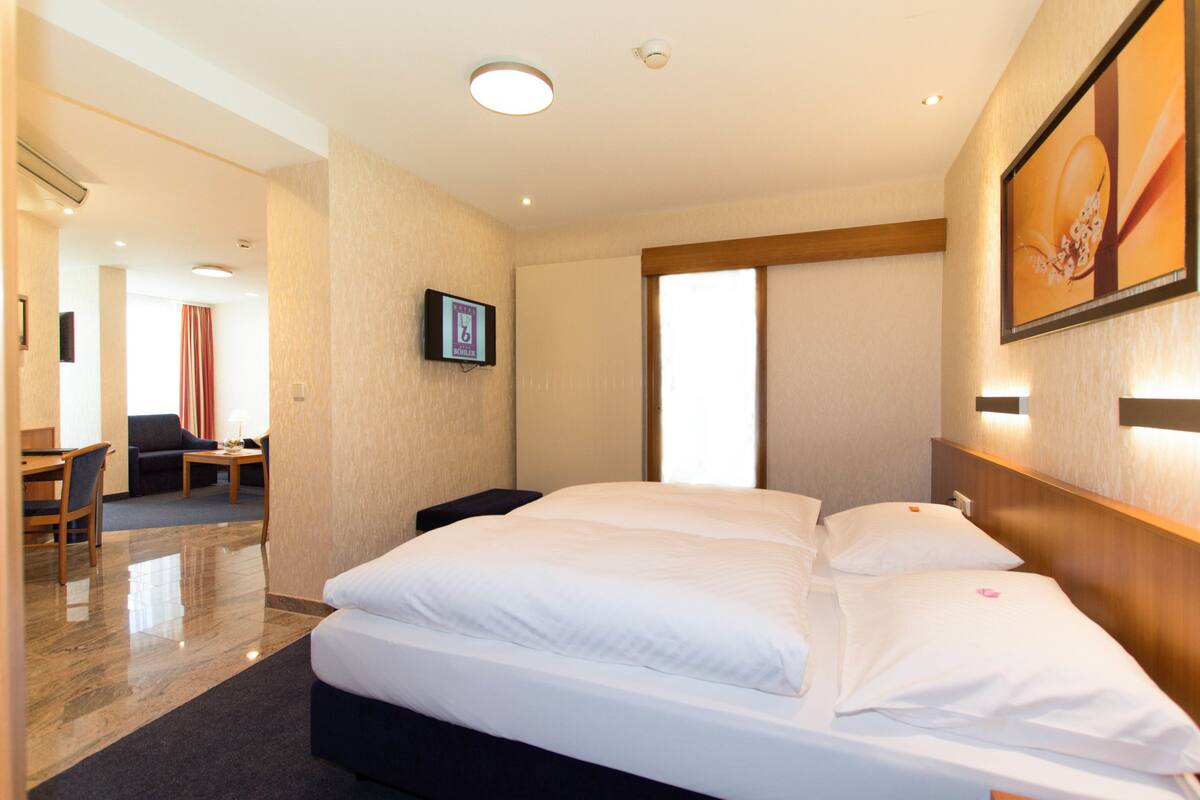 Ein Hotelzimmer mit einem großen Bett, einem Schreibtisch und einem Stuhl.