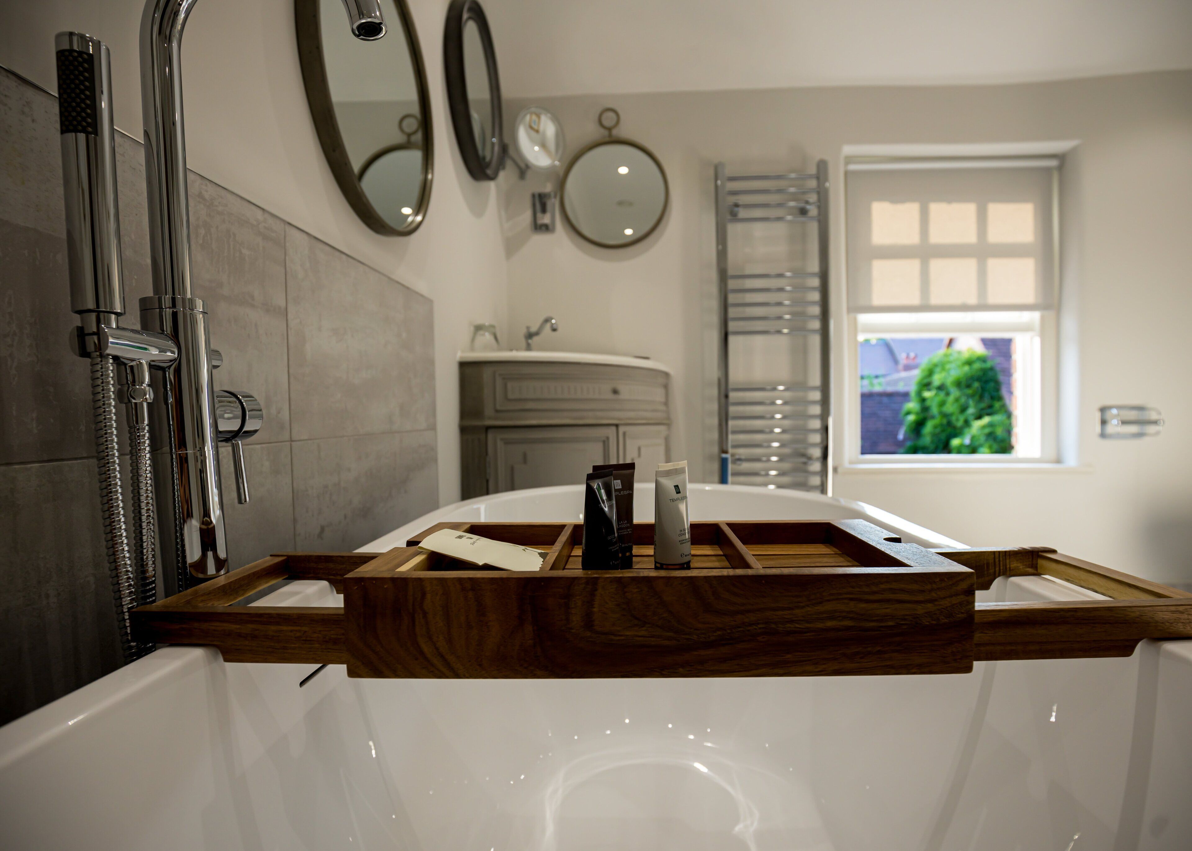A modern bathroom with a bathtub, a shower, and a vanity with a mirror.