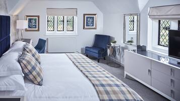 A bedroom with a bed, a chair, a TV, and a dresser.