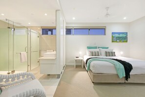 Une chambre à coucher moderne avec un lit, une table de chevet et une douche séparée par des parois en verre.