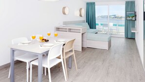 Une chambre moderne avec un coin repas, un lit et une vue sur la mer.