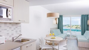 Une cuisine moderne équipée d’un four à micro-ondes, d’un évier et d’un coin repas avec une table et des chaises.