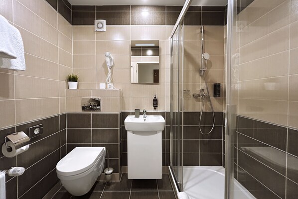 Un bagno moderno con toilette, lavandino e doccia.