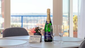 Ein Tisch mit einer Champagnerflasche, zwei Gläsern, einem Schild mit der Aufschrift 'Mit freundlichen Grüßen' und 'ORION Siberia' sowie einer Blumenkomposition.