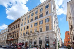 A multi-story building with a classical architectural style, featuring a ground floor with shops and a restaurant. - Nakissa Inn (Rome)