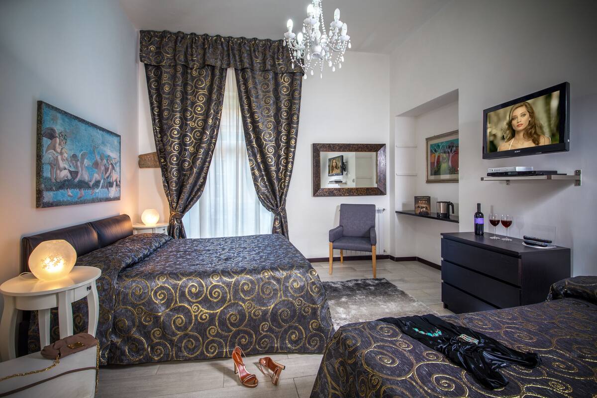 Une chambre à coucher avec un grand lit, une télévision, une chaise et une commode.