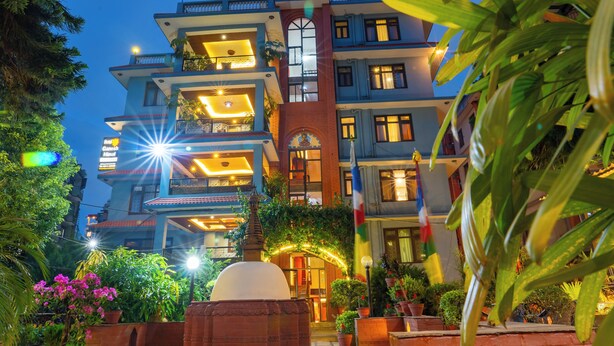 A multi-story hotel with balconies, a central archway, and potted plants. - Hotel Ganesh Himal (Kathmandu)