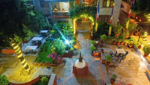 An outdoor courtyard with potted plants, a central fountain, and seating areas. - Hotel Ganesh Himal (Kathmandu)