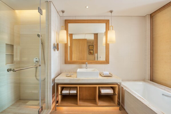 Een moderne badkamer met een glazen douchecabine, een grote spiegel en een bad.