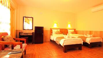 A hotel room with two beds, a sofa, a desk, and a mirror.