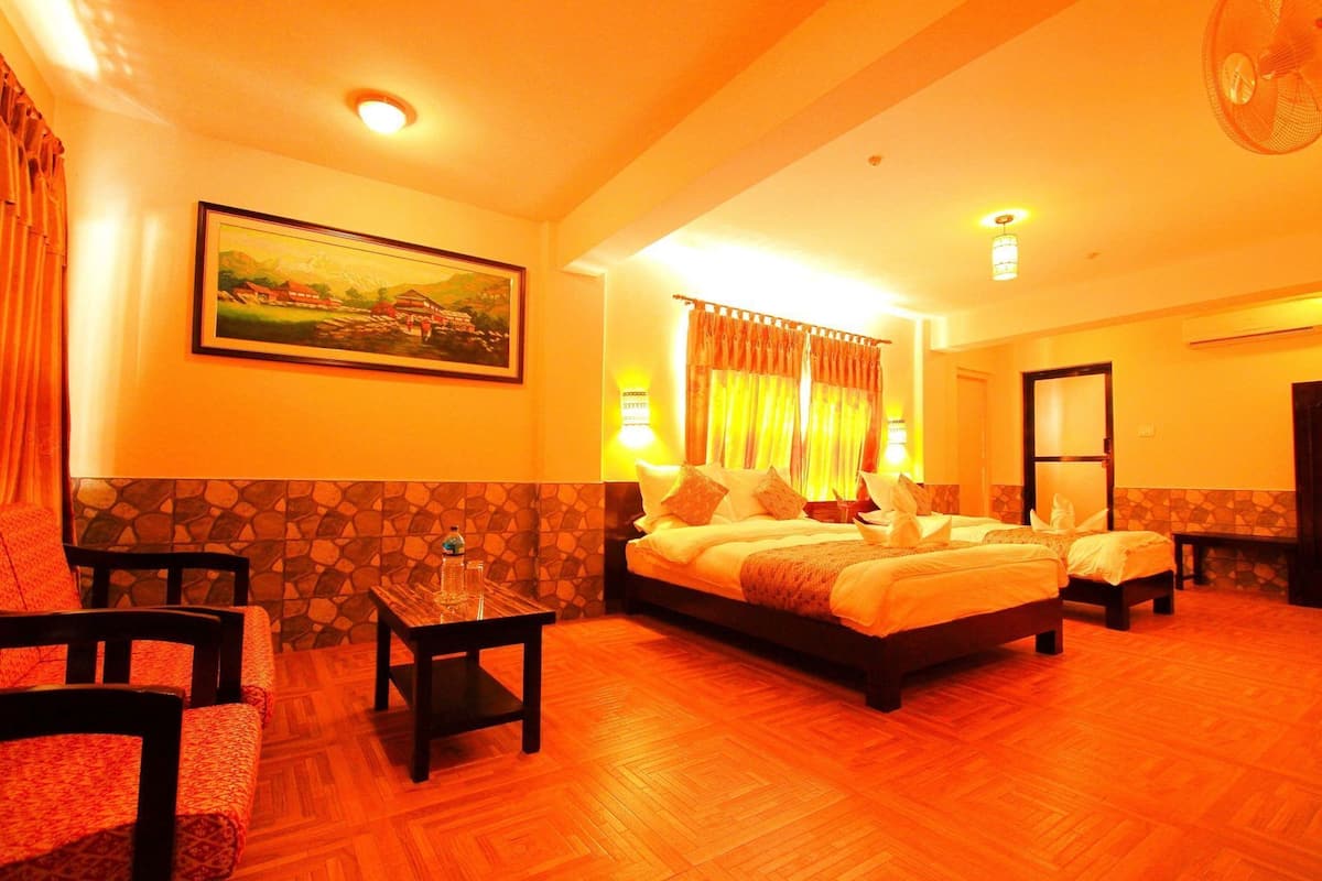 A hotel room with a bed, two bedside tables, a chair, a painting, and a door.