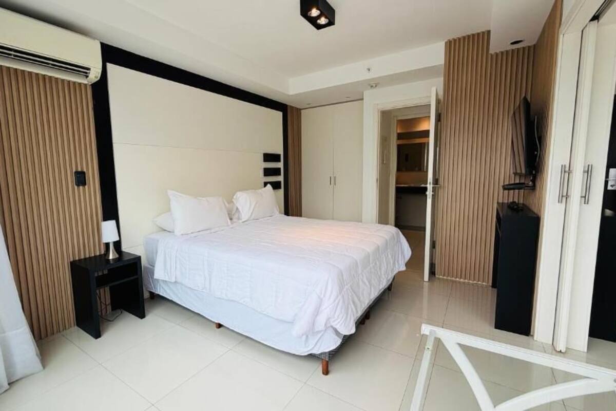 A bedroom with a bed, bedside table, and a wardrobe.