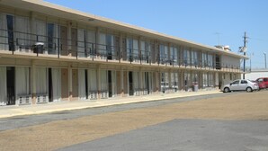 A two-story motel with a row of rooms on the ground floor and a balcony on the upper floor. - Sunrise Inn (Lake Charles)