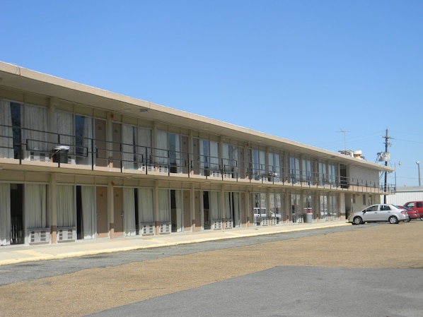 A two-story motel with a row of rooms on the ground floor and a balcony on the upper floor.
