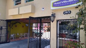 A hotel entrance with a gated entrance, a signboard, and a number '2415'. - Hotel Villa Del Sol (Guadalajara)