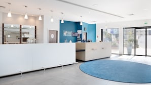 Un espace d’accueil moderne avec un mur d’accent bleu, un comptoir d’accueil et une vitrine.