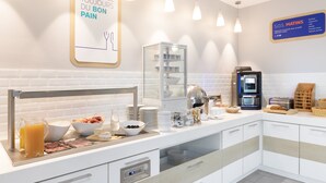 Un buffet de petit-déjeuner proposant une variété d’aliments et une machine à café.