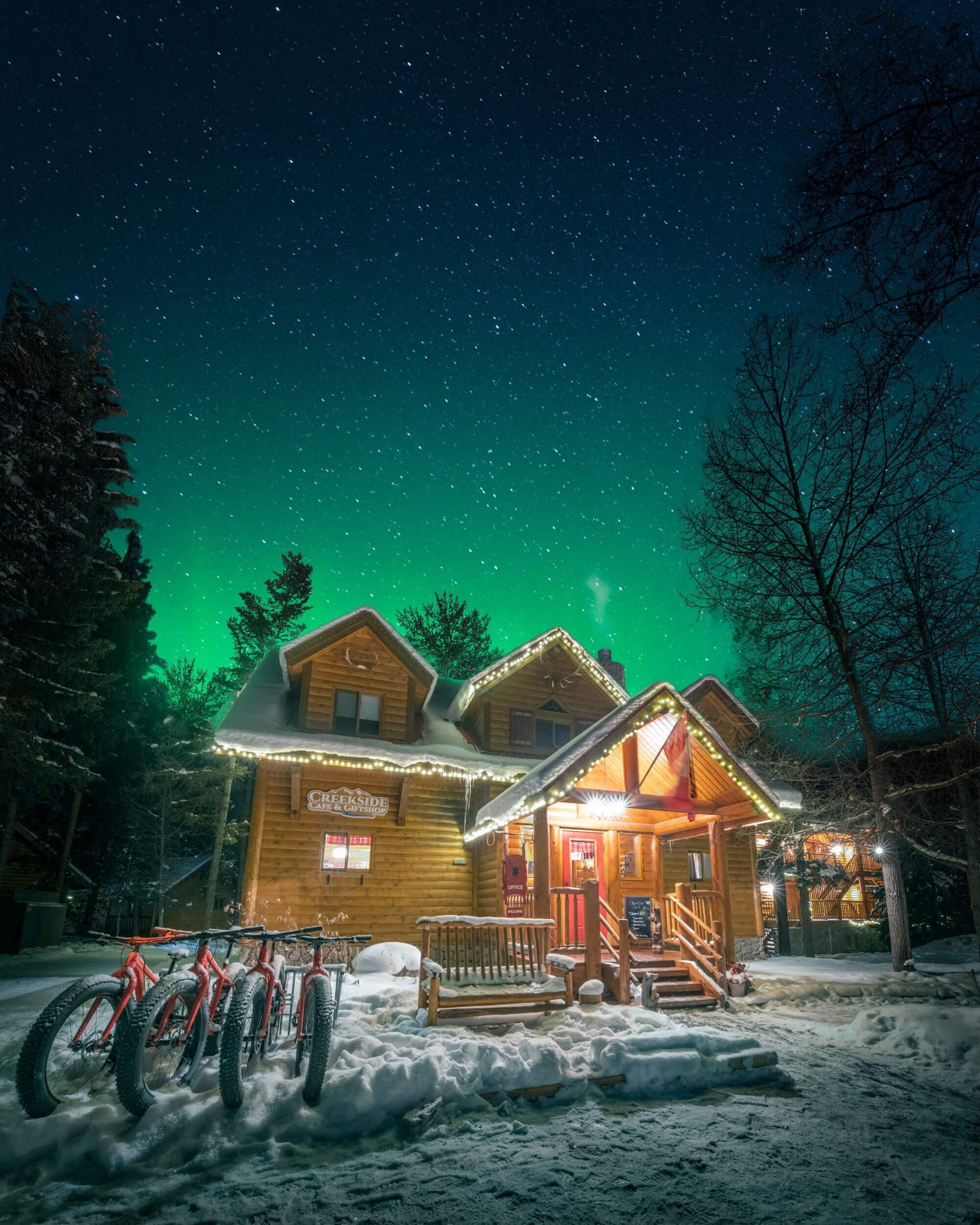 A log cabin with a porch, snow-covered ground, and a sign that reads "Creekside Cafe & Giftshop."