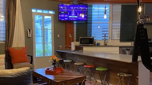 Un salon moderne avec un canapé, une table basse en bois et un téléviseur fixé au mur.