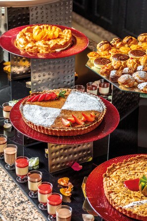 Un présentoir à desserts avec divers pâtisseries et douceurs disposées sur des plateaux.
