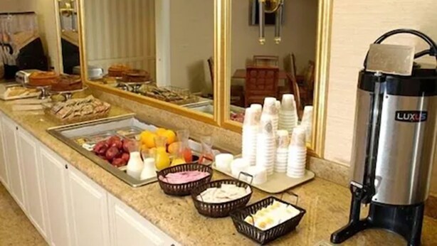 Een ontbijtbuffet met diverse etenswaren en een koffieapparaat.