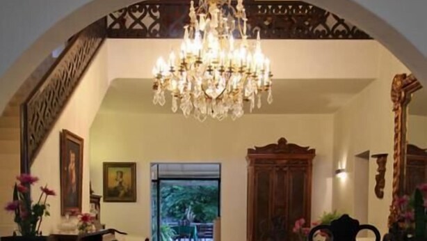 A spacious lobby with a grand chandelier, a wooden staircase, and a view of the outdoors. - Casa Madonna La Providence Hotel Boutique (Guadalajara)