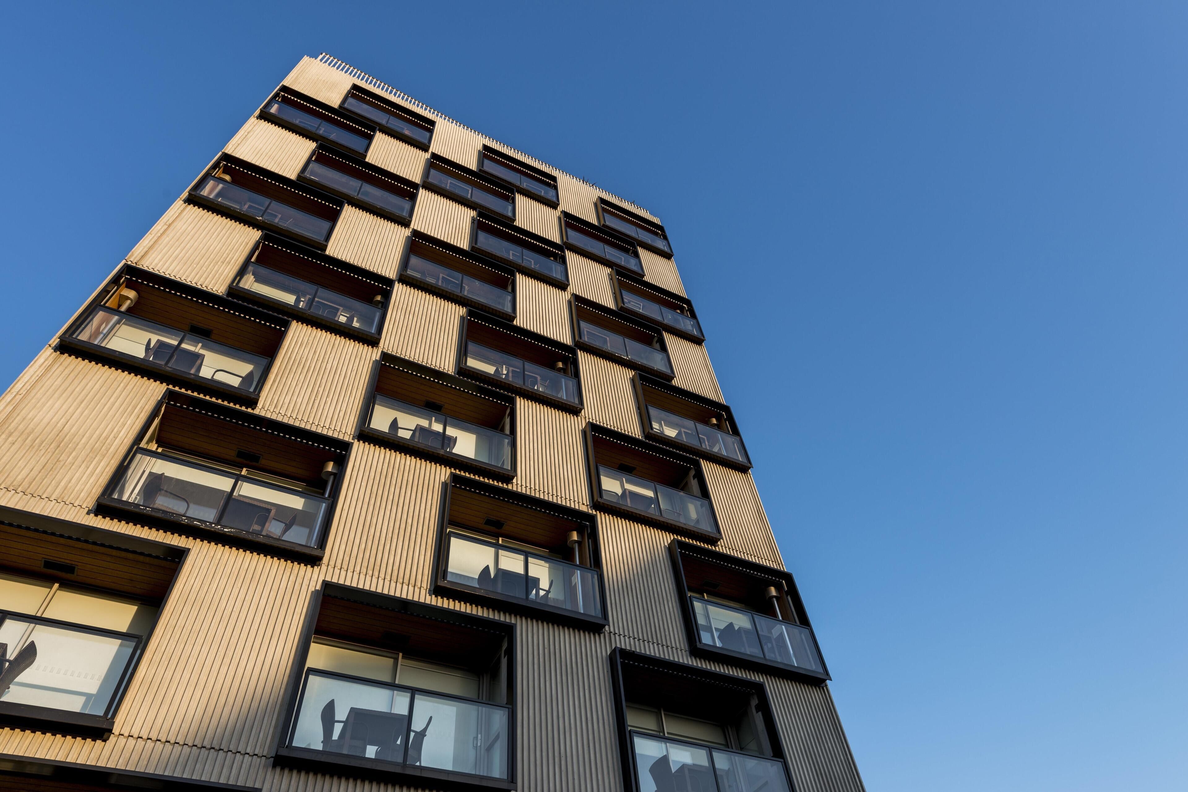 A high-rise building with multiple balconies and large windows.