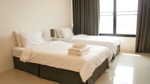 A hotel room with two beds, a large window, and a view of the outside. - Chaba Place (Hua Hin)