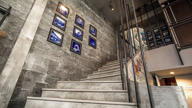 Una escalera con un muro de piedra y cuadros enmarcados.