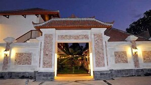 A traditional building with a tiled roof and a central entrance framed by stone pillars. - Aquarius Beach Hotel (Denpasar)