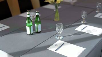 A table with two bottles of green liquid, a glass, and name cards.