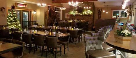 A restaurant with high ceilings, exposed beams, and a variety of seating options including tables and booths.