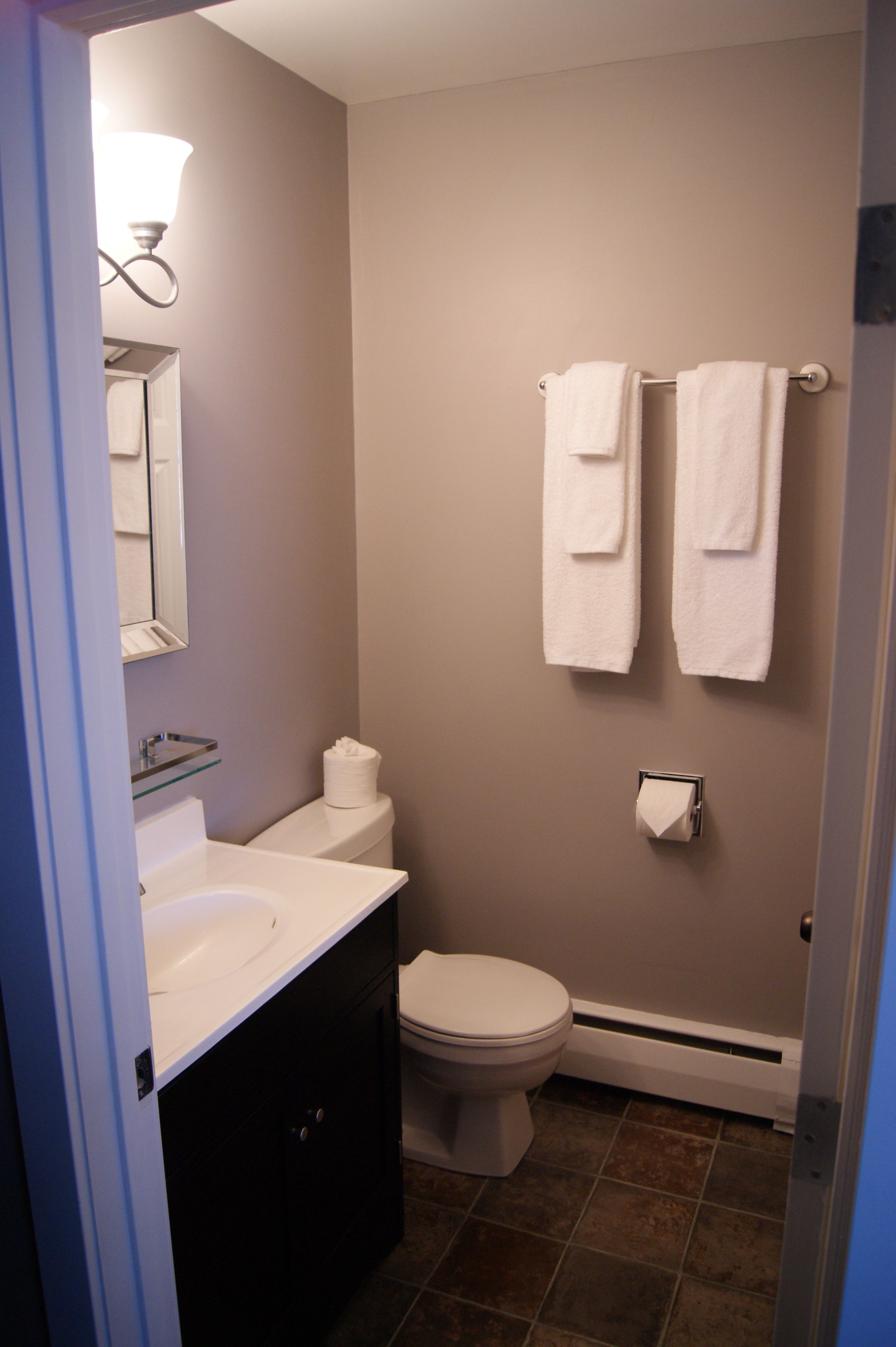 Een kleine badkamer met toilet, wastafel en handdoekhouder.