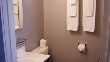 Een kleine badkamer met toilet, wastafel en handdoekhouder.