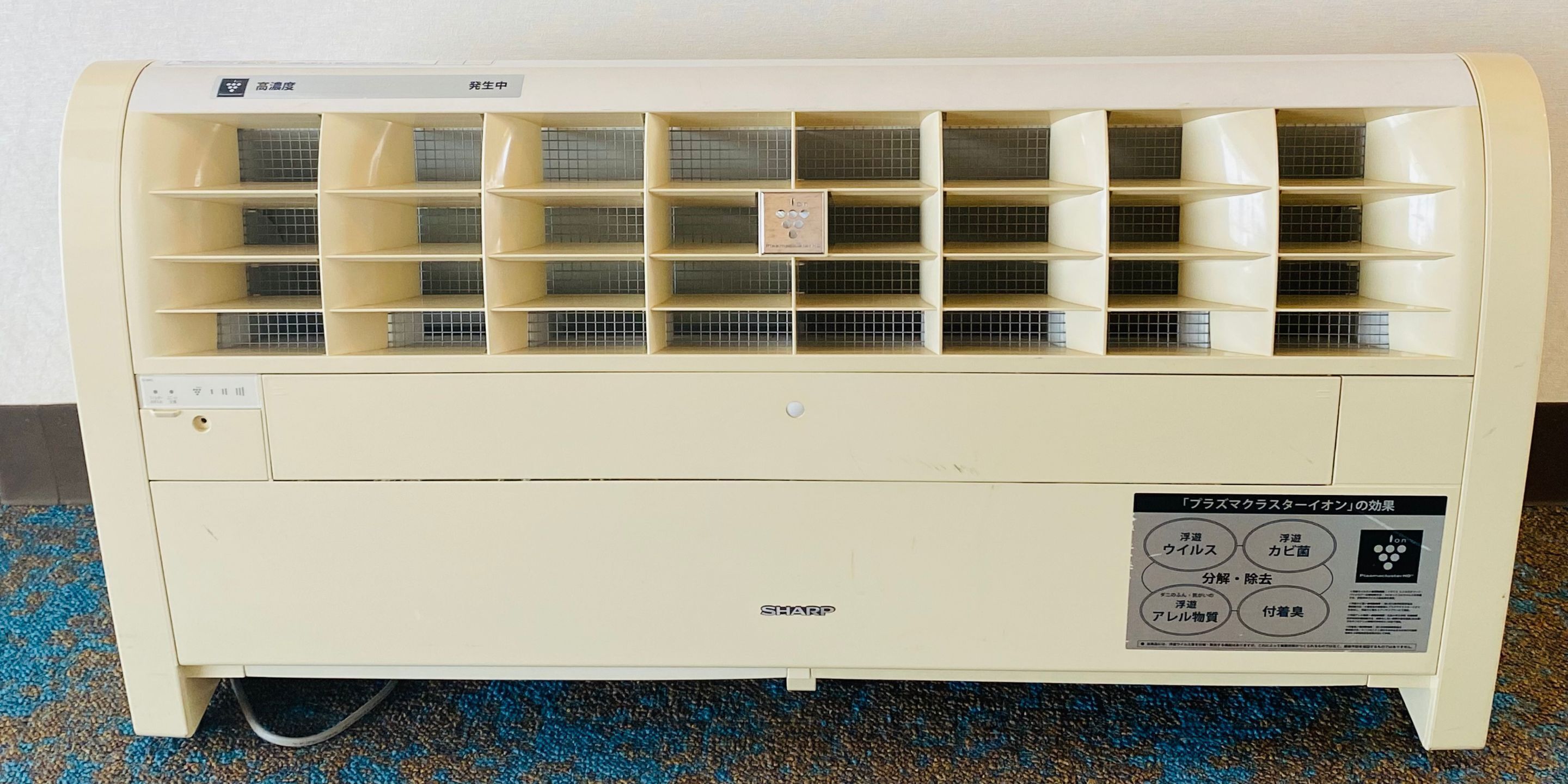 A white air conditioner with multiple vents and a control panel.