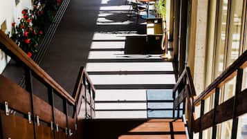 Una escalera conduce a un área de descanso con vistas a la calle.